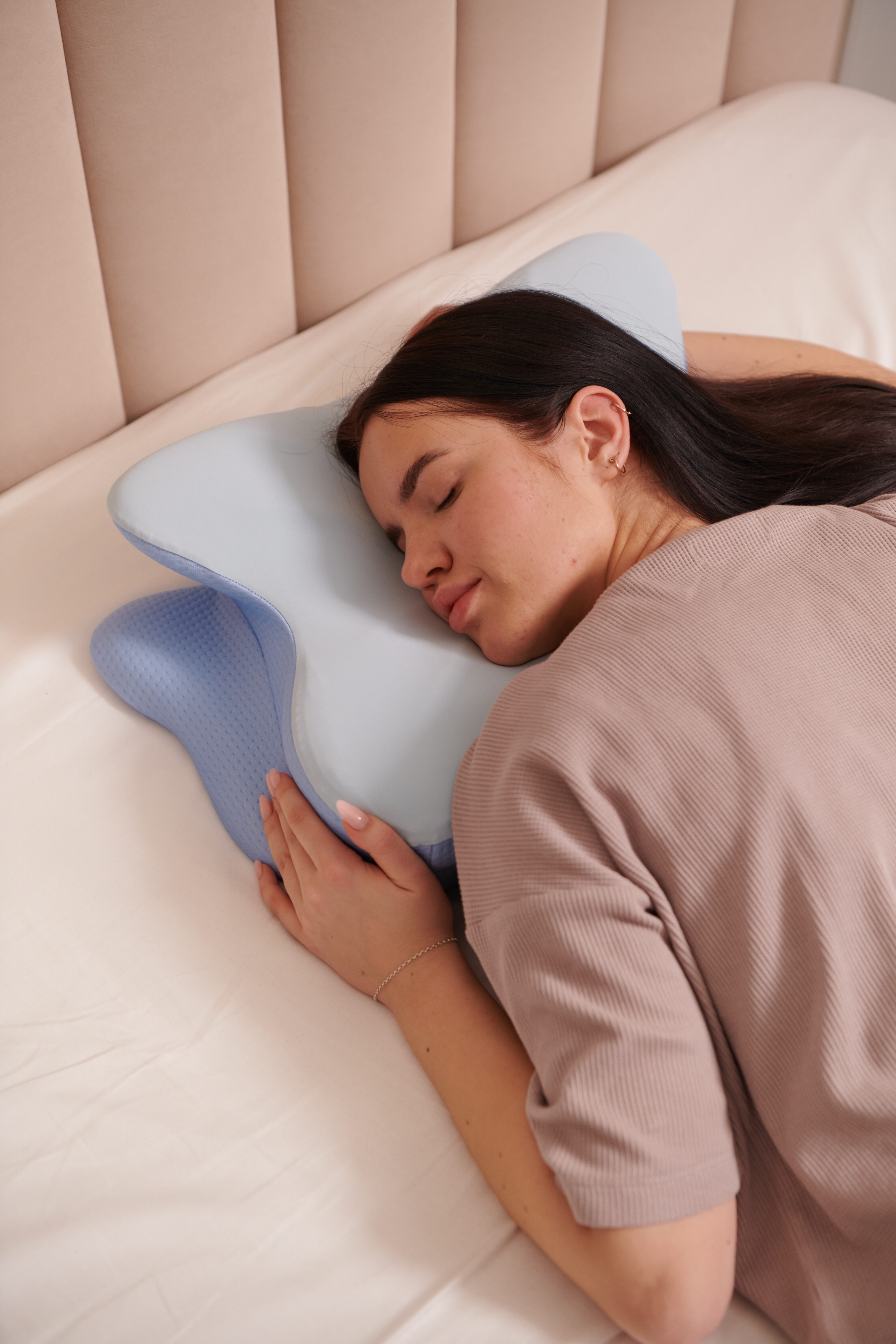 Woman smiling and hugging her Derila Ergo pillow with genuine joy