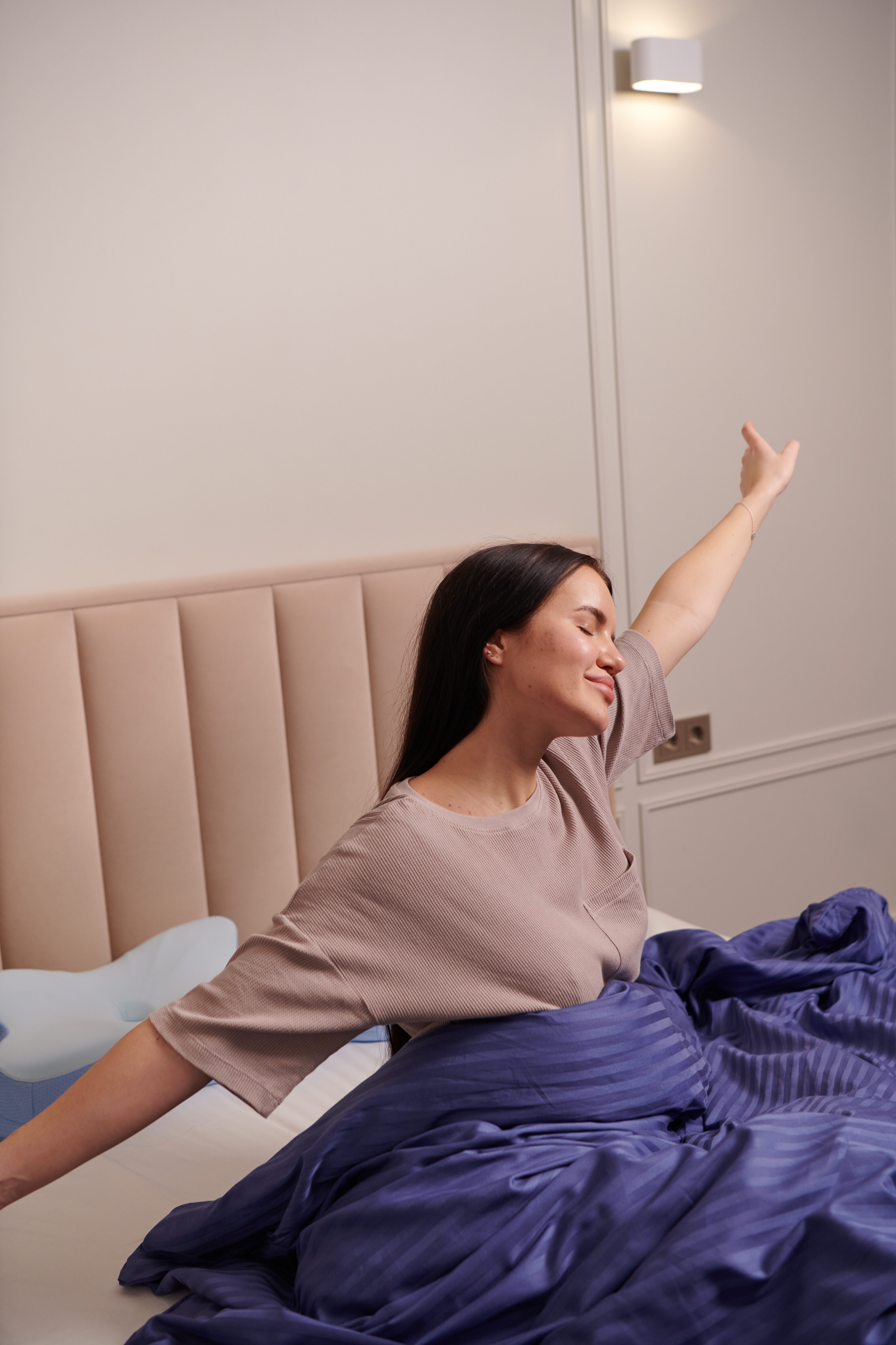Woman stretching joyfully upon waking up after a restorative night's sleep