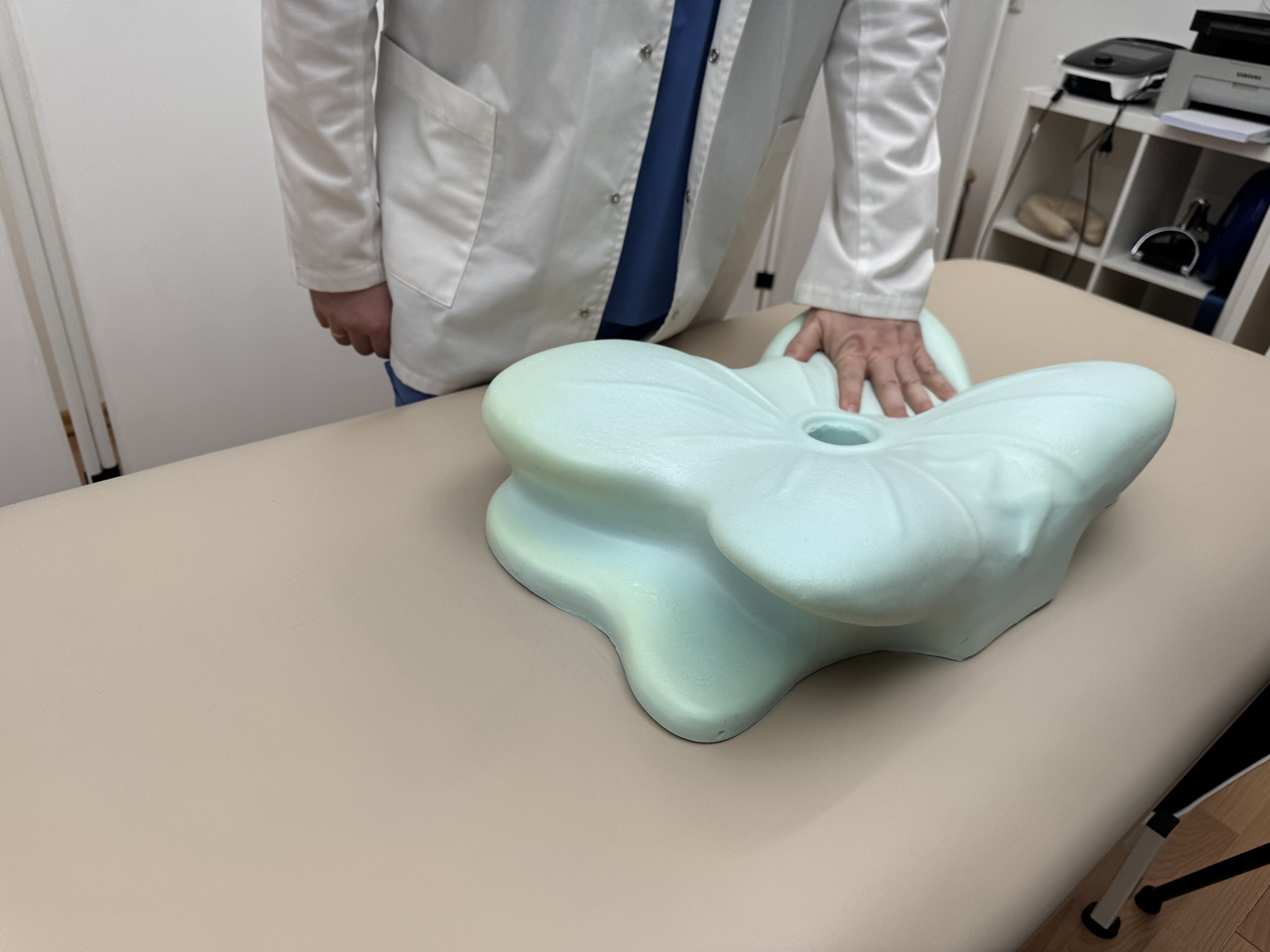 Doctor demonstrating the adaptive memory foam zones of the ergonomic pillow